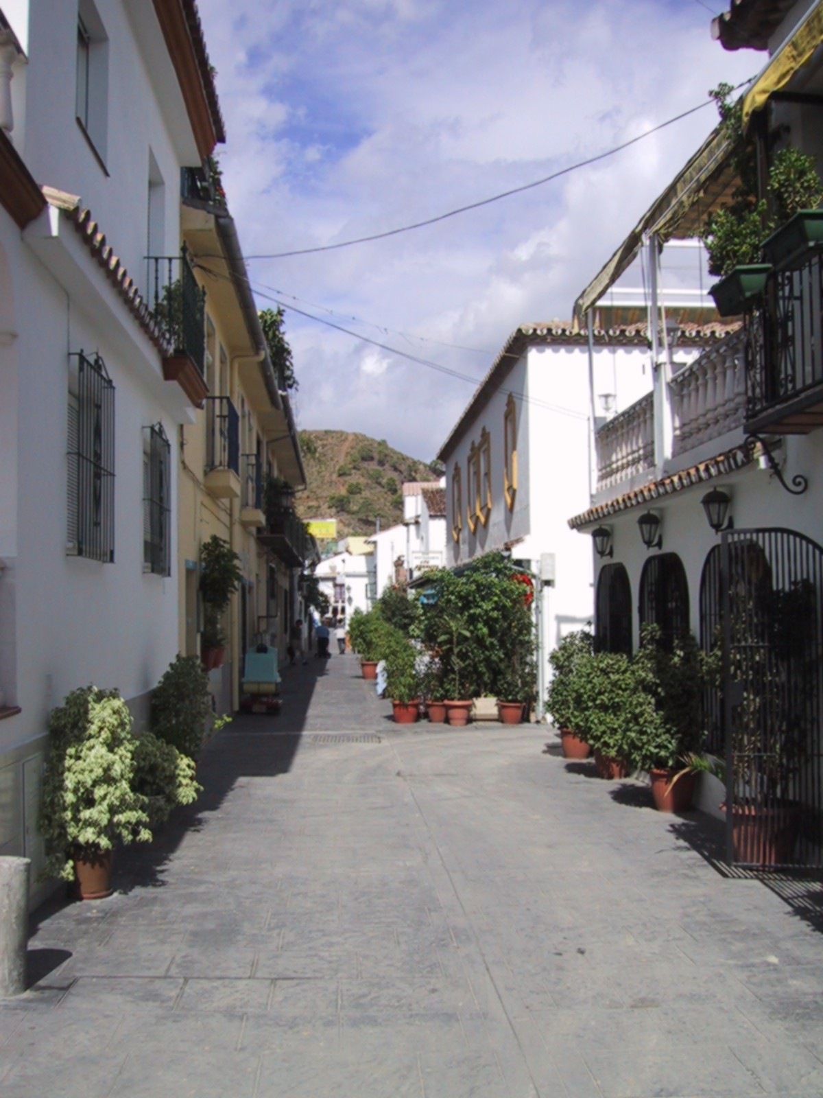 Straatbeeld in Benahavís, Spanje, met witte gebouwen en planten